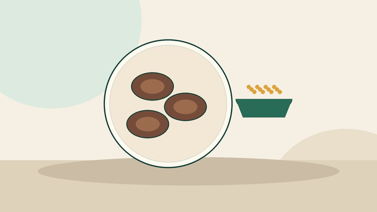 Ragi rotis on a plate beside a bowl of grains