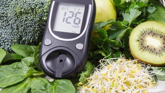 हरी सब्ज़ियों, कीवी और अंकुरित दानों के पास रखा एक glucometer